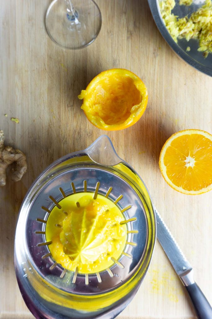 An orange pressed in a juicer