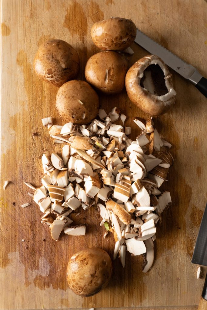 Chopped mushrooms on a wooden chopping board