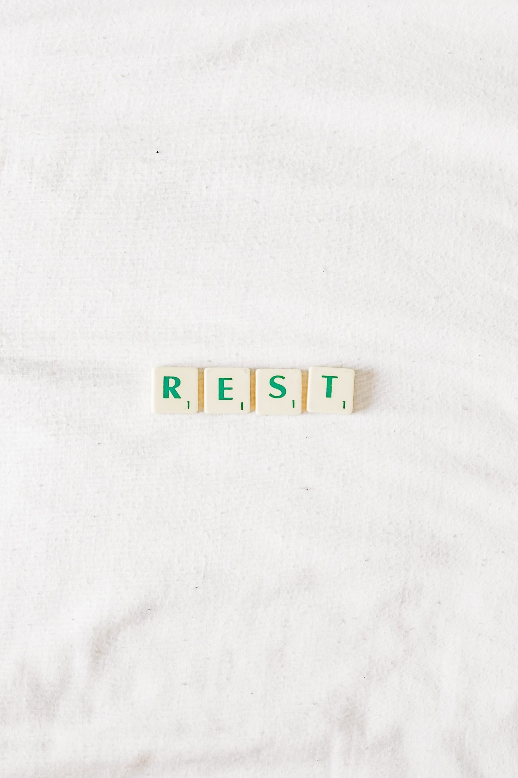 Rest in scrabble letters on a white background