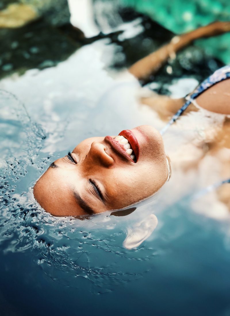Woman having her eyes closed and swimming in water