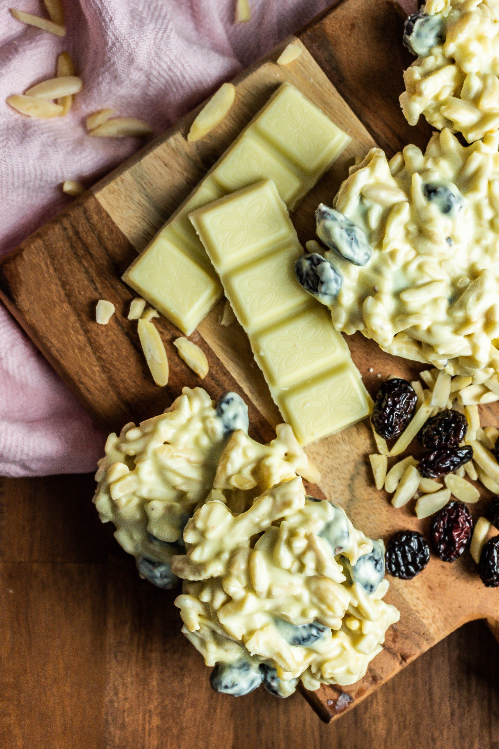 Shaved Almond and Cranberry White Chocolate Cookies with white chocolate, shaved almonds, and cranberries scattered around the cookies