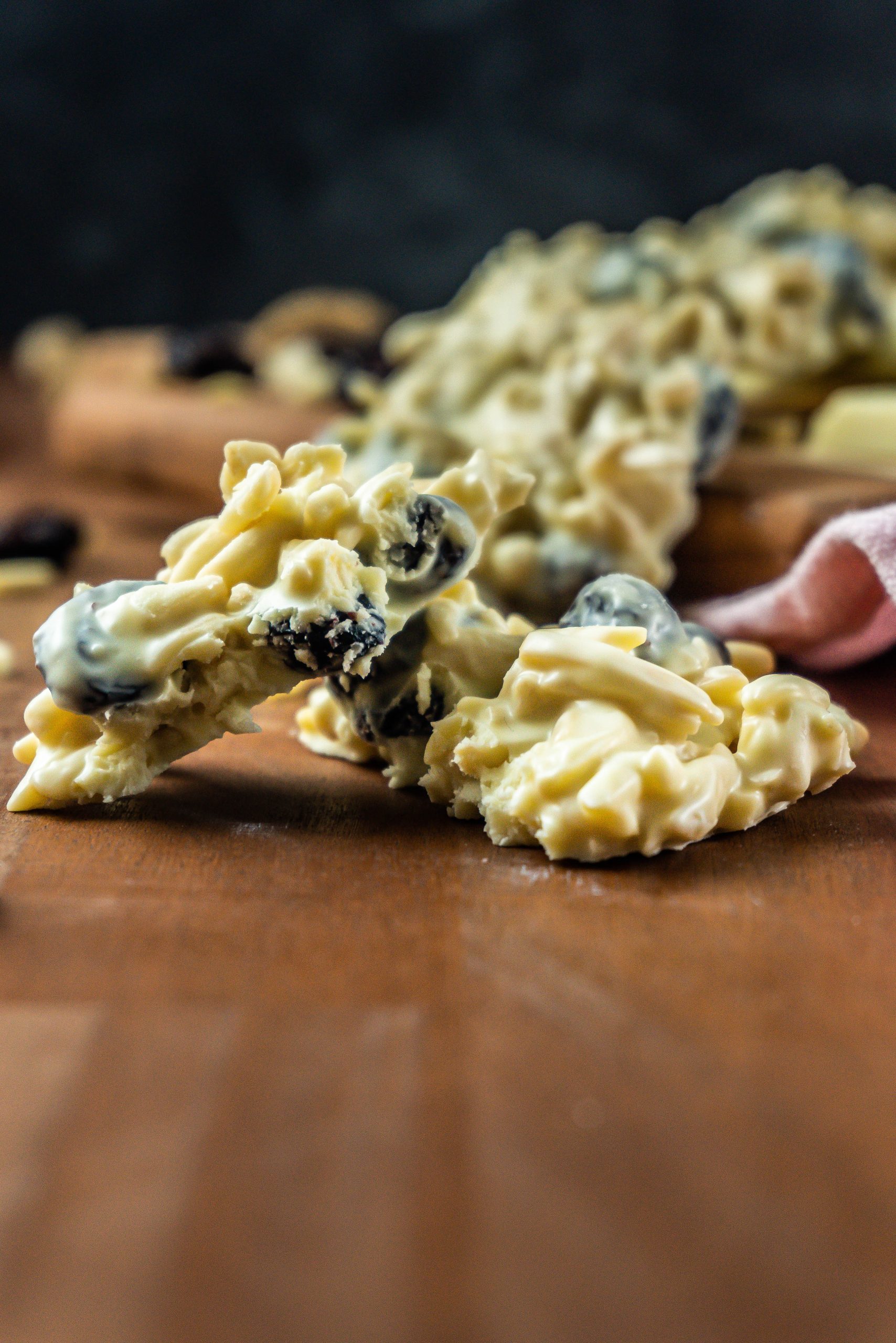 Shaved Almond and Cranberry White Chocolate Cookie broken in the middle and photographed up close