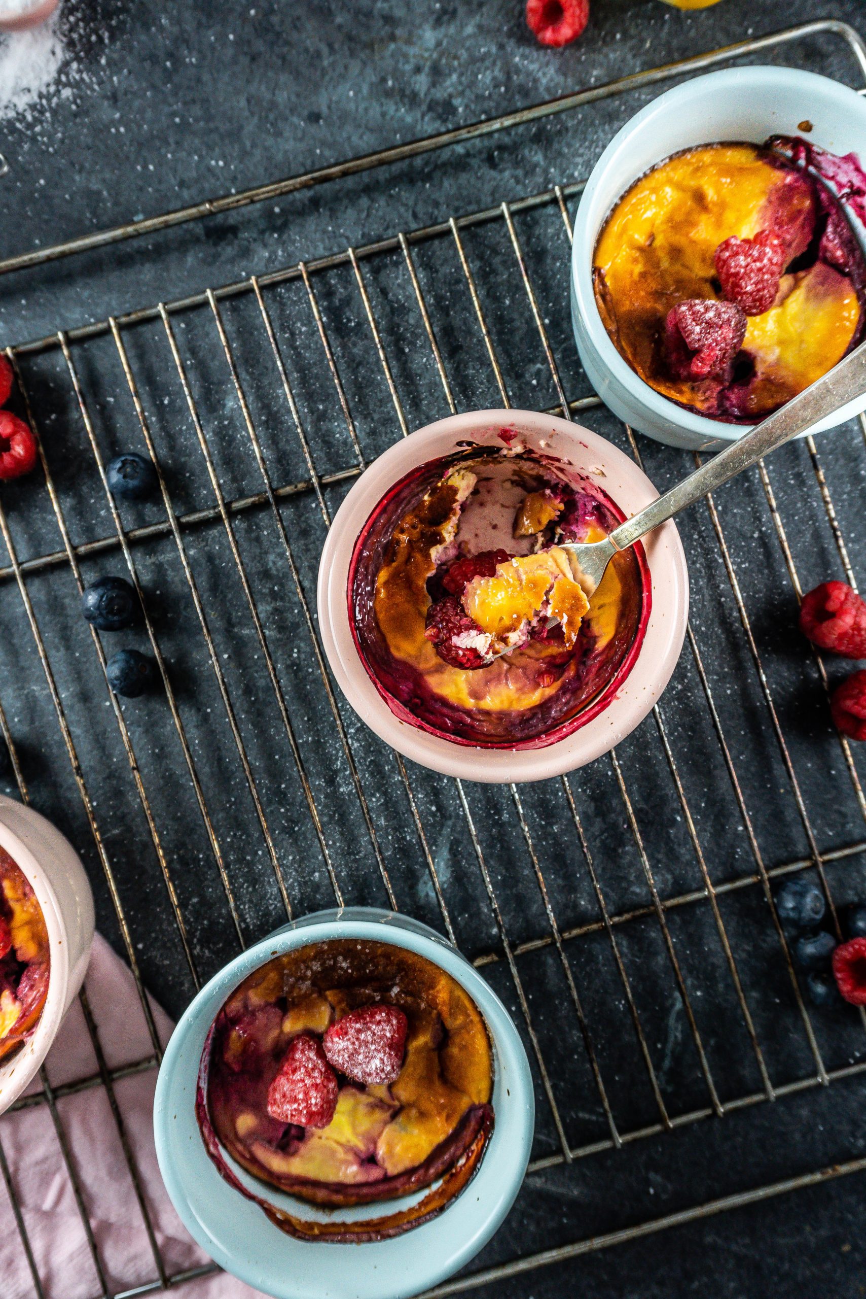 Five Minute Mini Cheesecakes with a fork tugging into one of the mugs; photographed from above