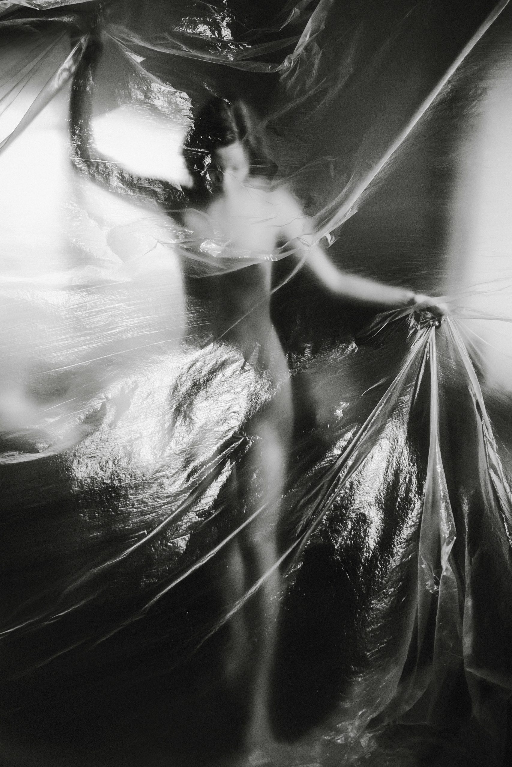A woman fighting with her body behind a plastic sheet