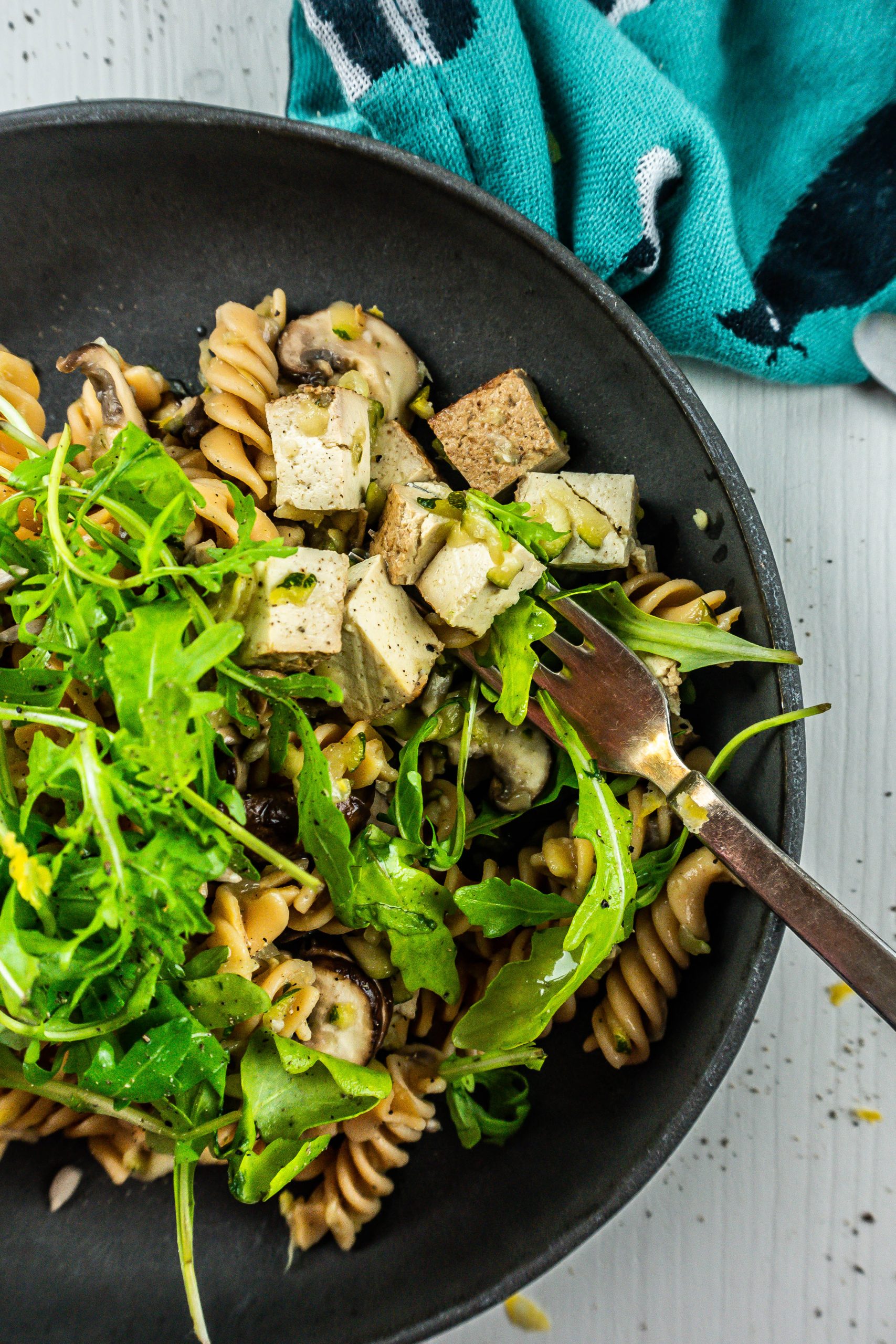 15-Minute Summer Pasta on a plate with a fork tugging into the pasta; photographed up close