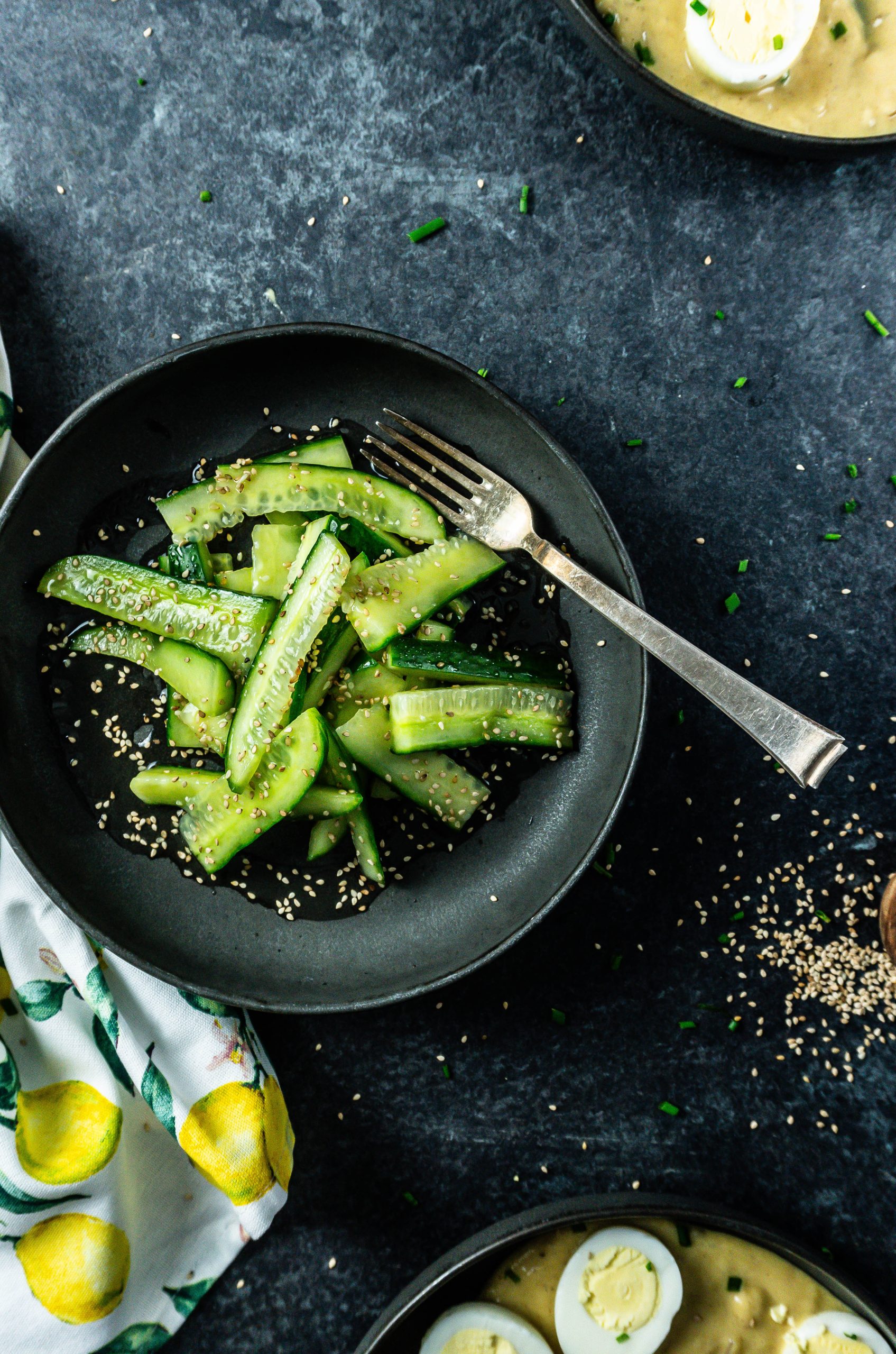 Japanese-Inspired Cucumber Salad with a fork on the plate and sesame seeds scattered in the background; photographed from above