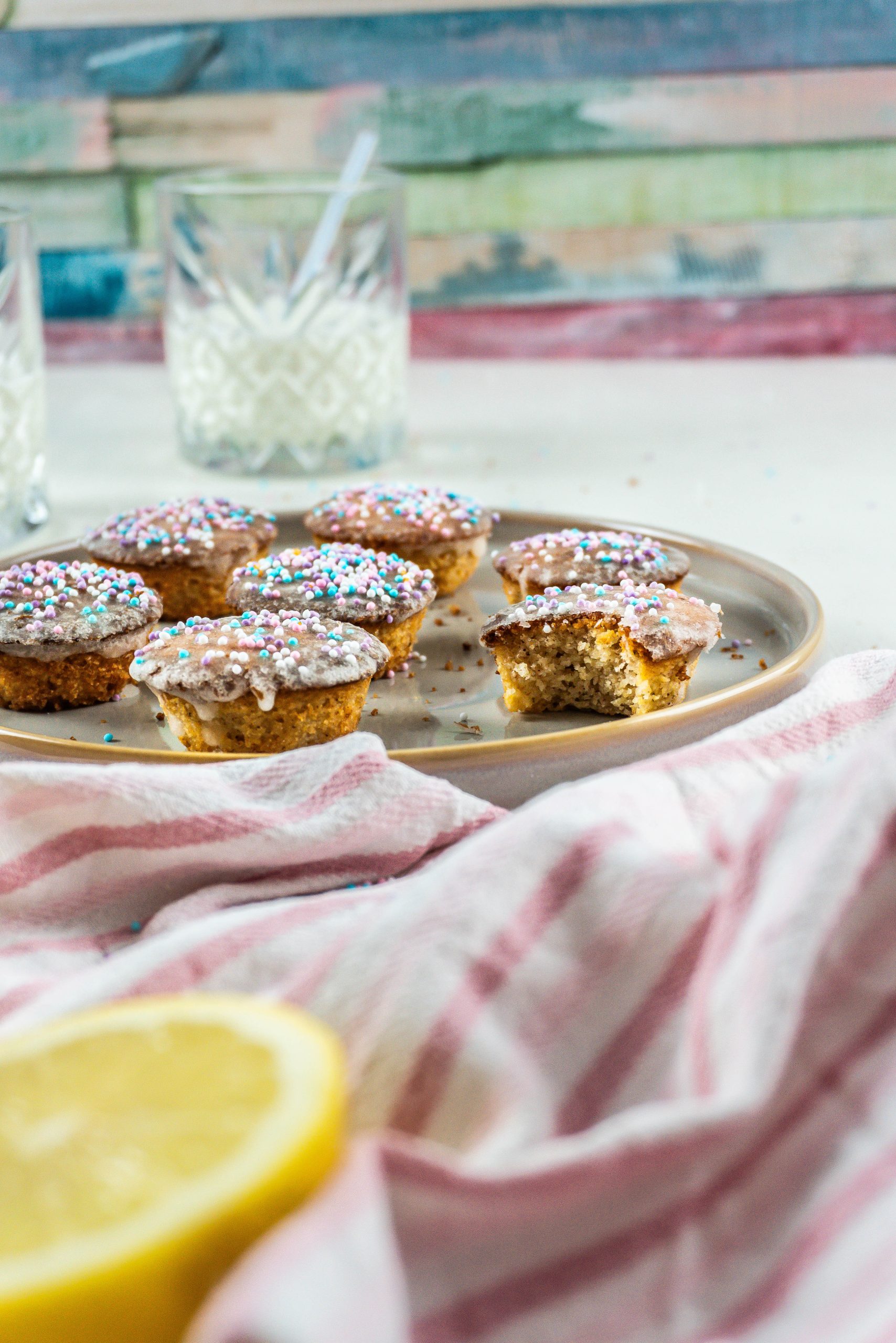 A bite being taken out of a Lemon Mascarpone Mini Muffin on a plate