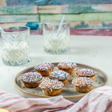 Lemon Mascarpone Mini Muffins on a small plate with two glasses of milk in the background and some sprinkles surrounding the plate