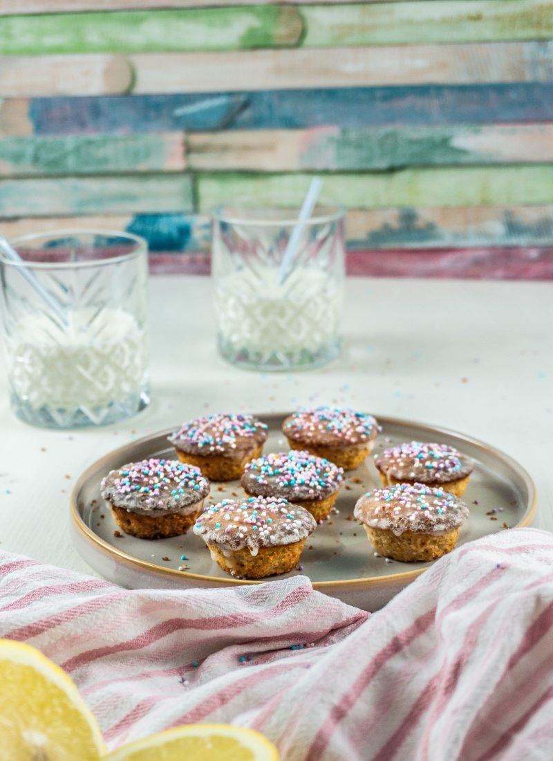 Lemon Mascarpone Mini Muffins on a small plate with two glasses of milk in the background and some sprinkles surrounding the plate