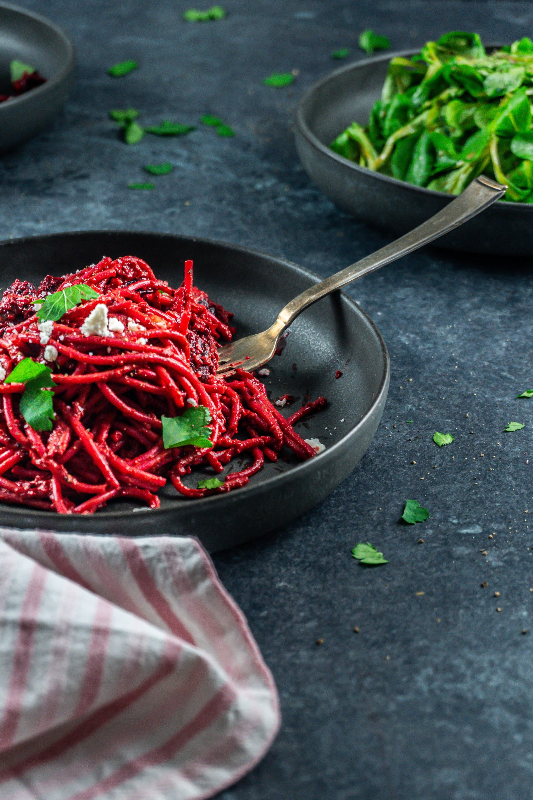 Creamy blender beetroot pasta with crumbled feta and chopped parsley; photographed from above with a fork tugging into the dish