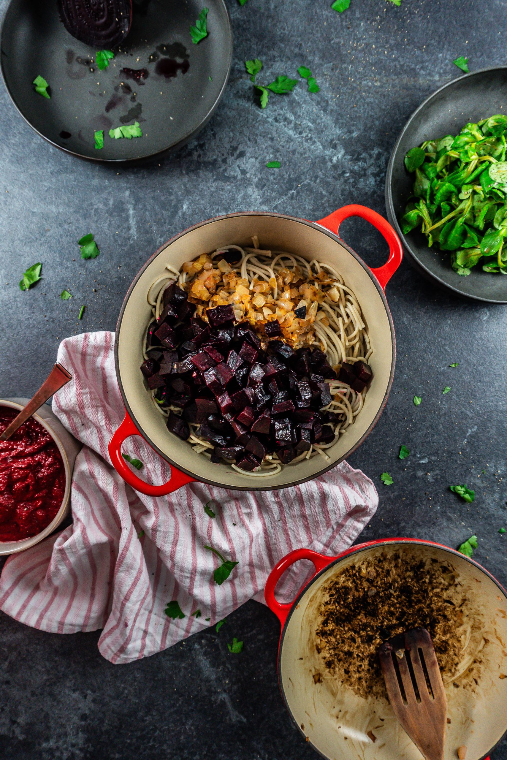Gluten-free noodles, fried onions, and cut up beets ready to be mixed in a pot