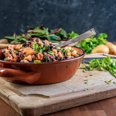 Blitva - Croatian Swiss Chard and Potatoes in a brown bowl with a spoon stuck into it