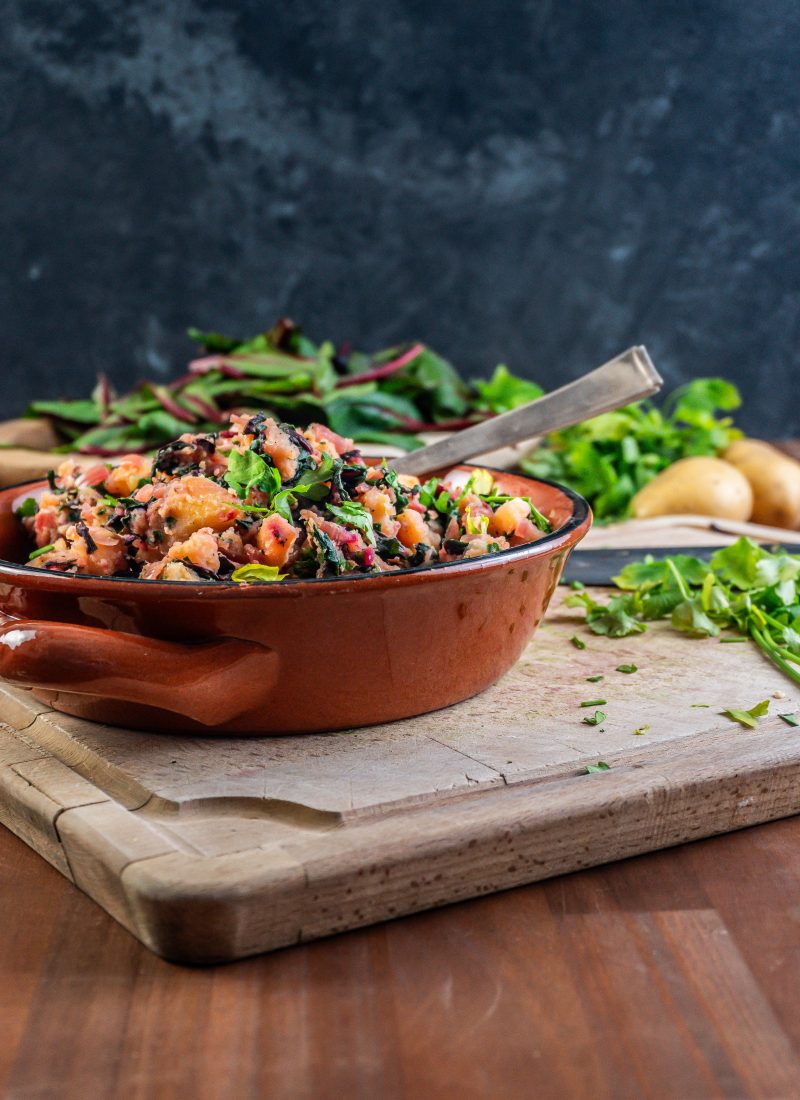 Blitva - Croatian Swiss Chard and Potatoes in a brown bowl with a spoon stuck into it