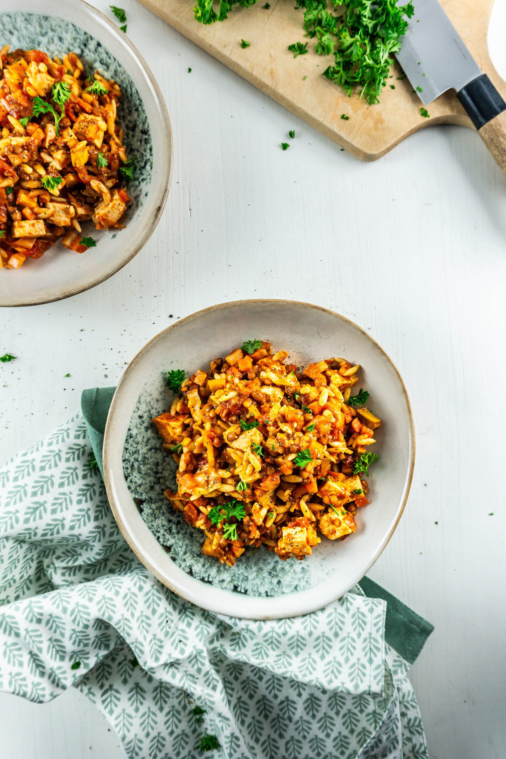 Comforting Tomato Noodle Soup on a plate with some parsley strewn about