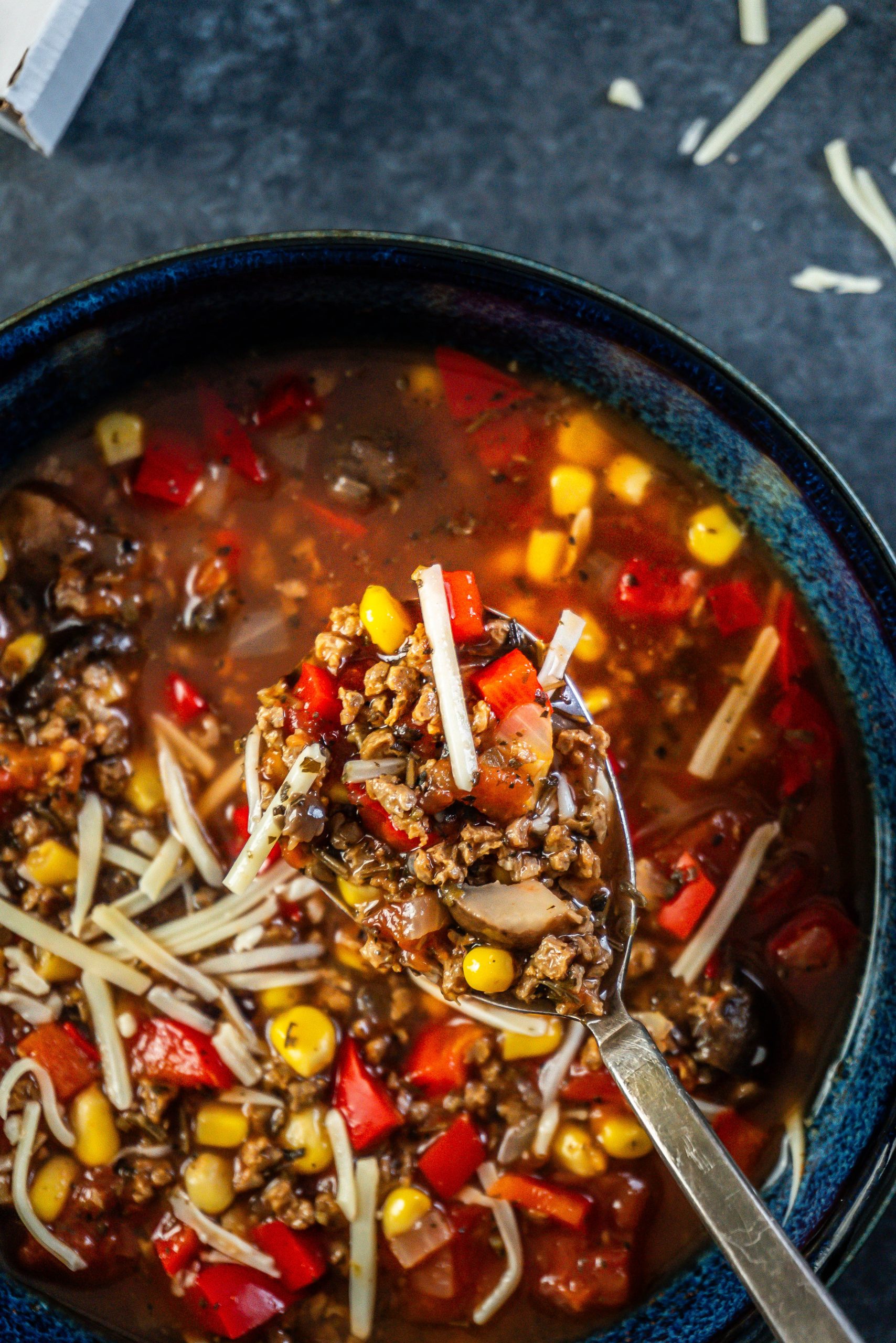 Hearty Vegan Pizza Soup Bowl up close on a spoon