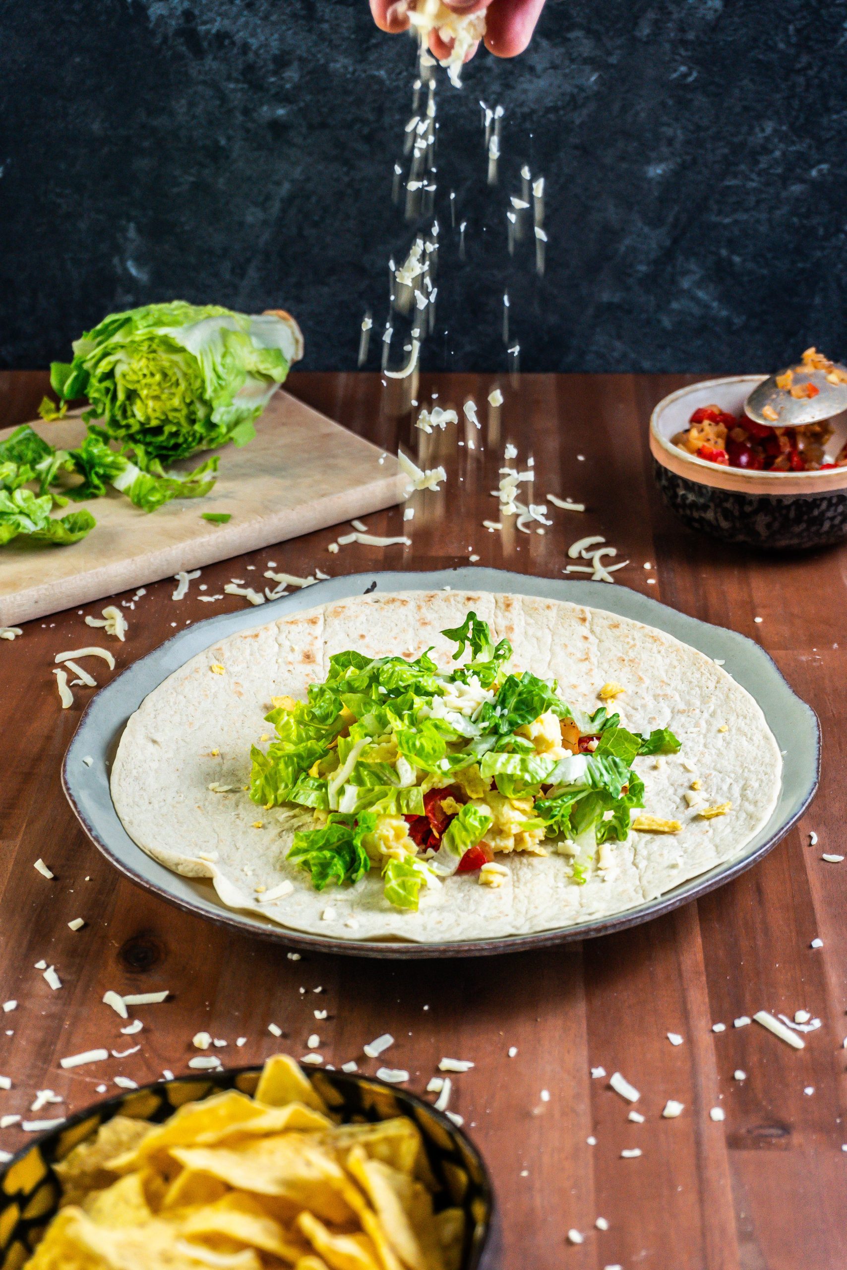 15-Minute Vegetarian Lunch Crunch Wrap in the process of being made, with some cheese sprinkled on top