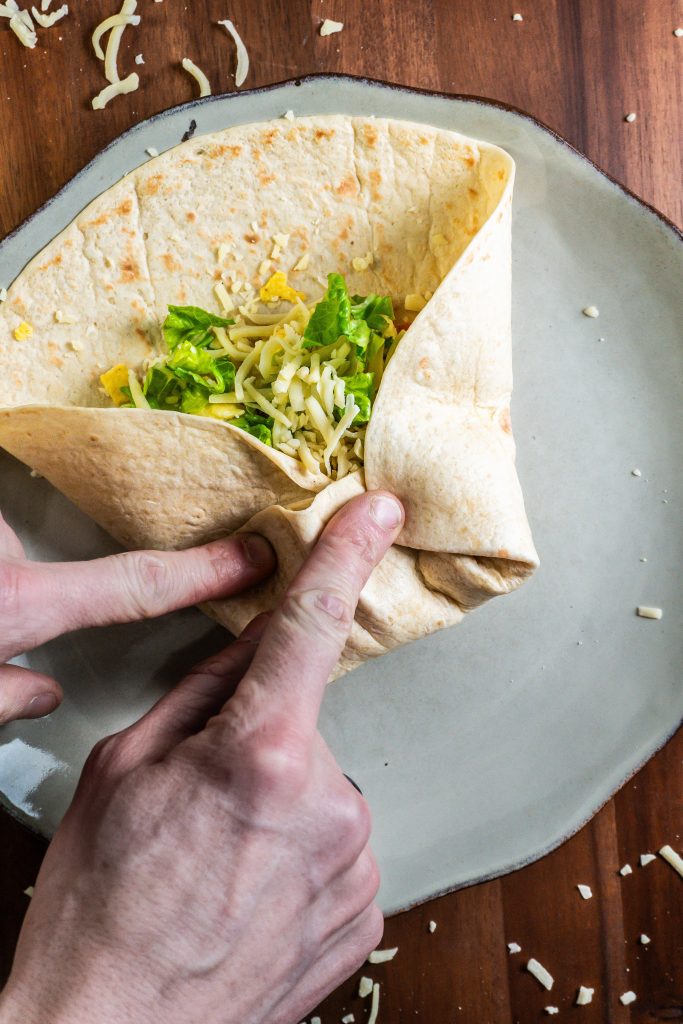 15-Minute Vegetarian Lunch Crunch Wrap being folded in order to be baked