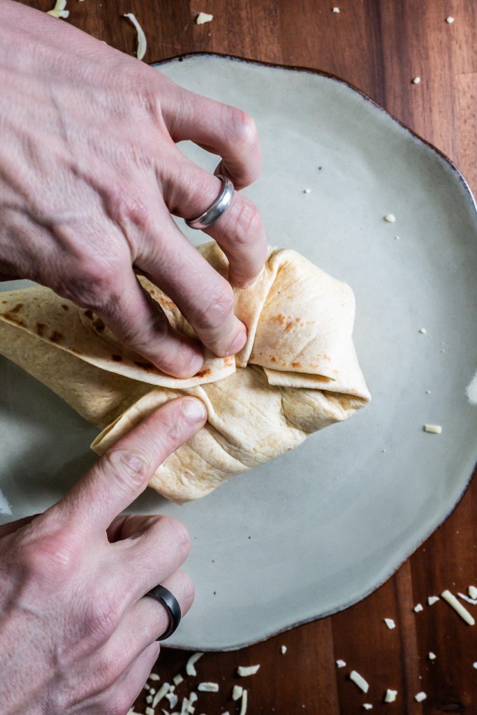 15-Minute Vegetarian Lunch Crunch Wrap being folded in order to be baked