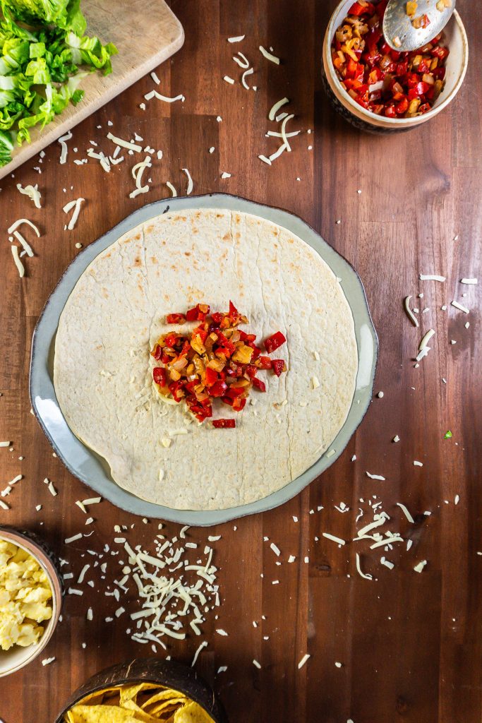 Wrap with fried onion and red peppers surrounded by other ingredients for the 15-Minute Vegetarian Lunch Crunch Wrap