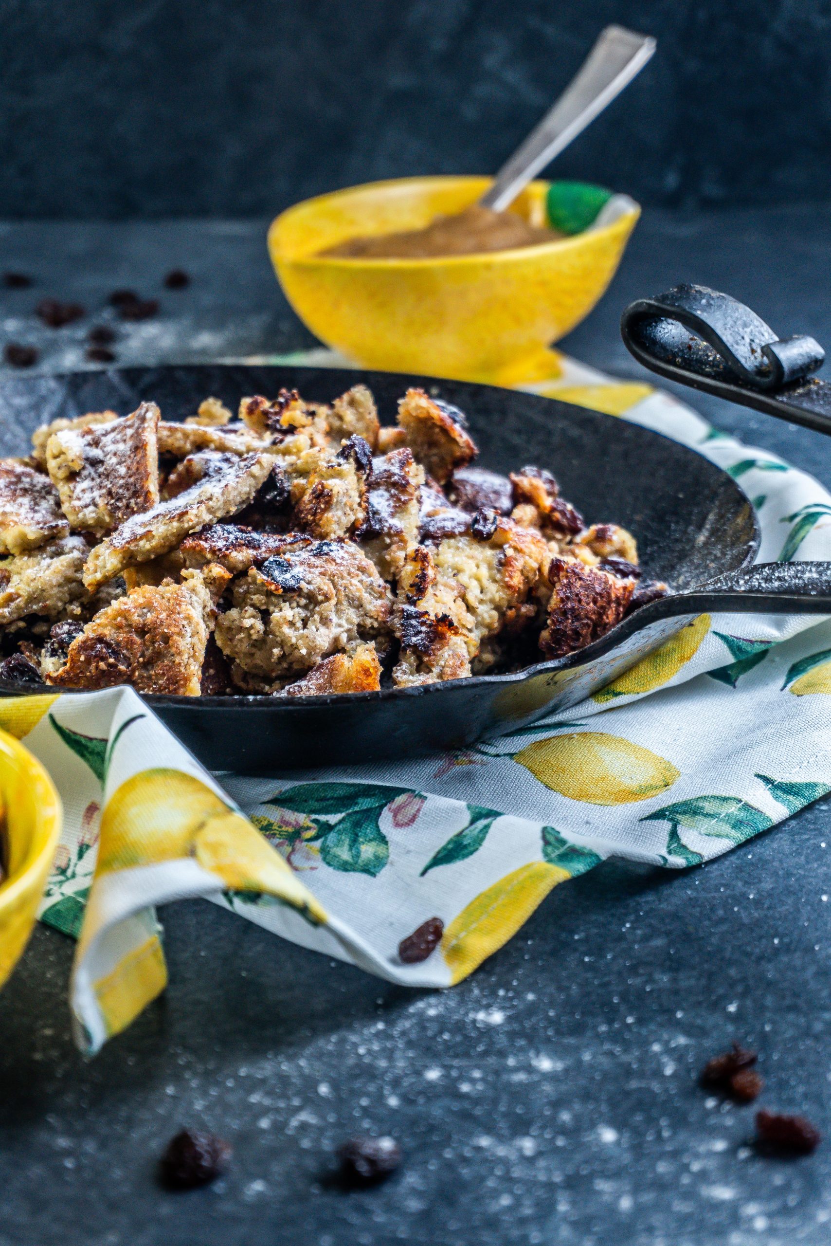 Gluten-free Kaiserschmarrn in a cast iron pan with some dusted xylitol on top and some apple sauce in the back