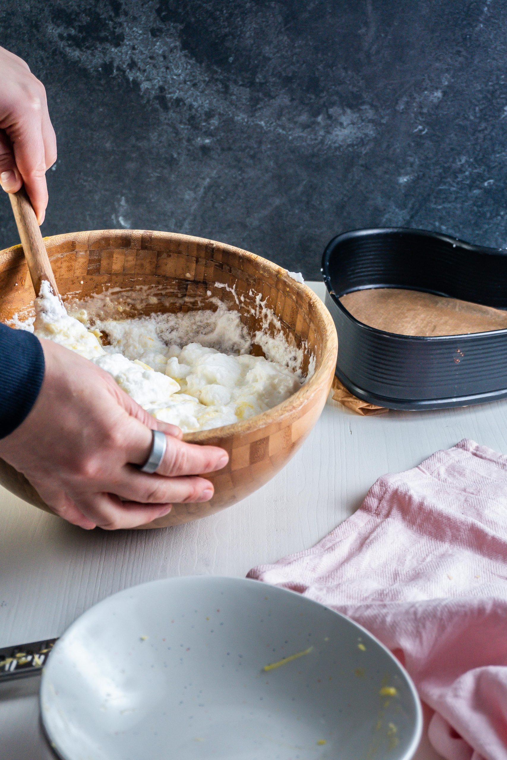 Egg whites are being mixed under a batter in a bowl