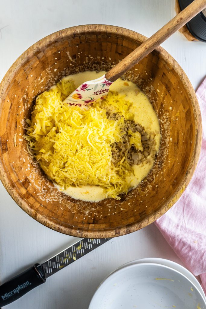 Egg yolks, almonds, grated potatoes, and polenta being mixed in a bowl