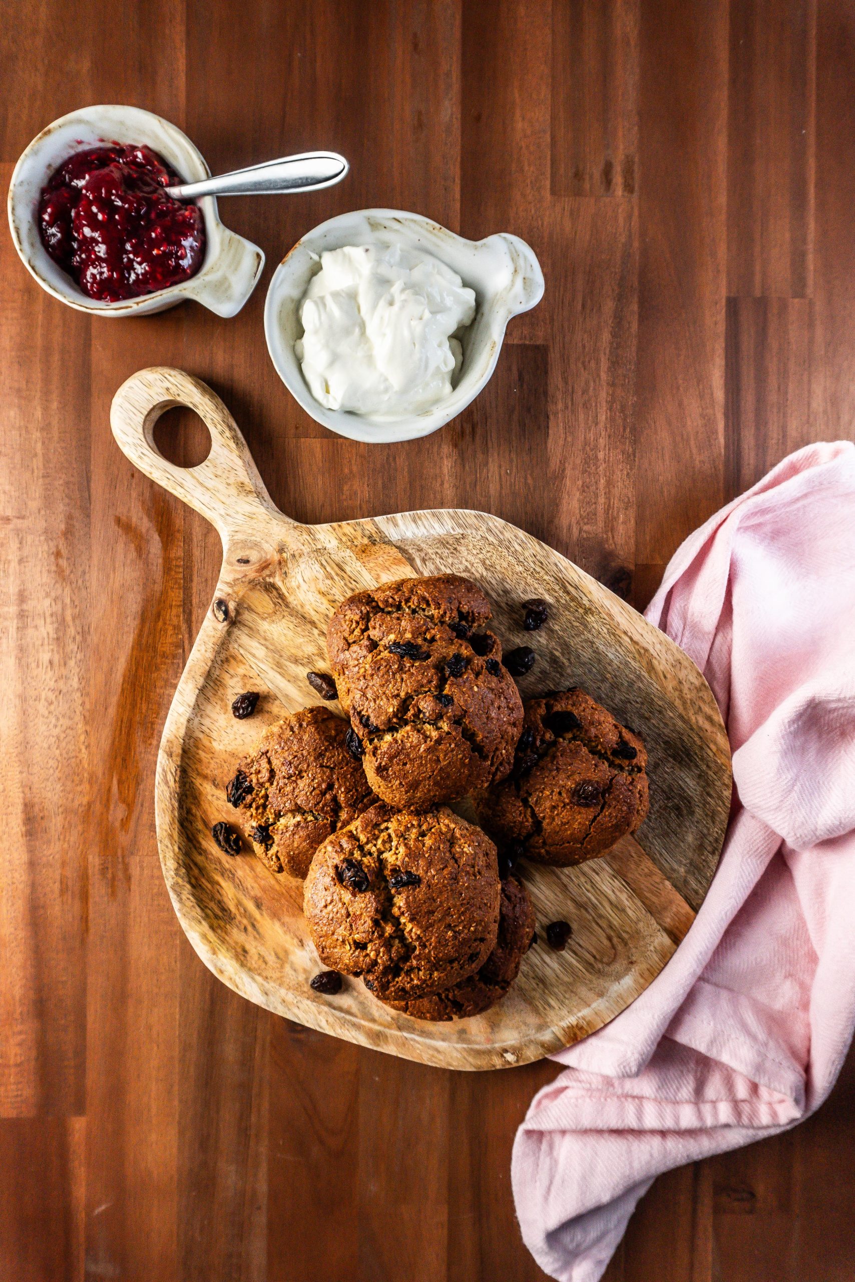 Cinnamon Orange Raisin Scones arranged on a platter with some jam and yogurt visible to the side