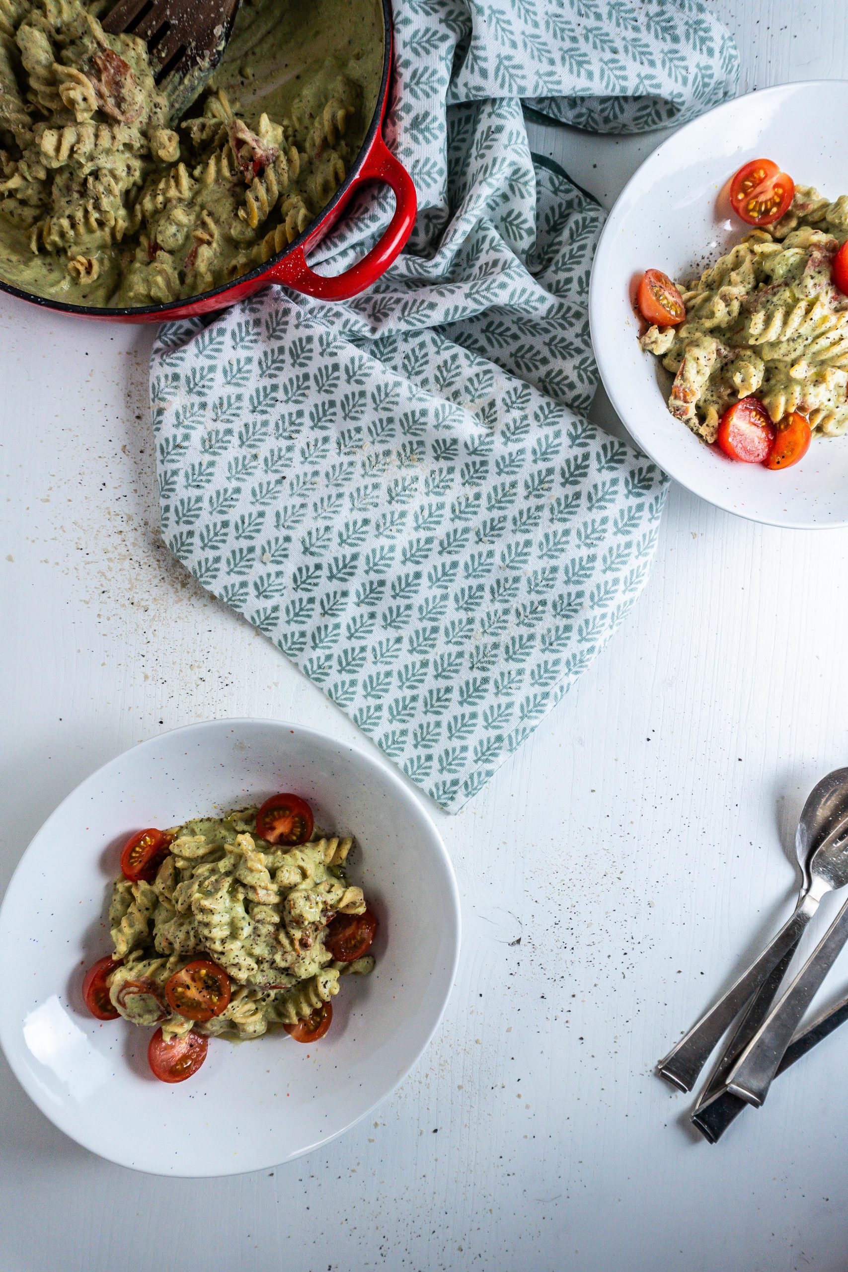 Creamy Avocado Pasta Recipe plated in two bowls, with the casserole dish that the pasta was made in visible to the side