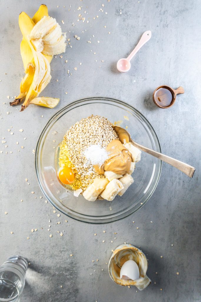 Oats, peanut butter, banana, an egg, and baking powder in a bowl