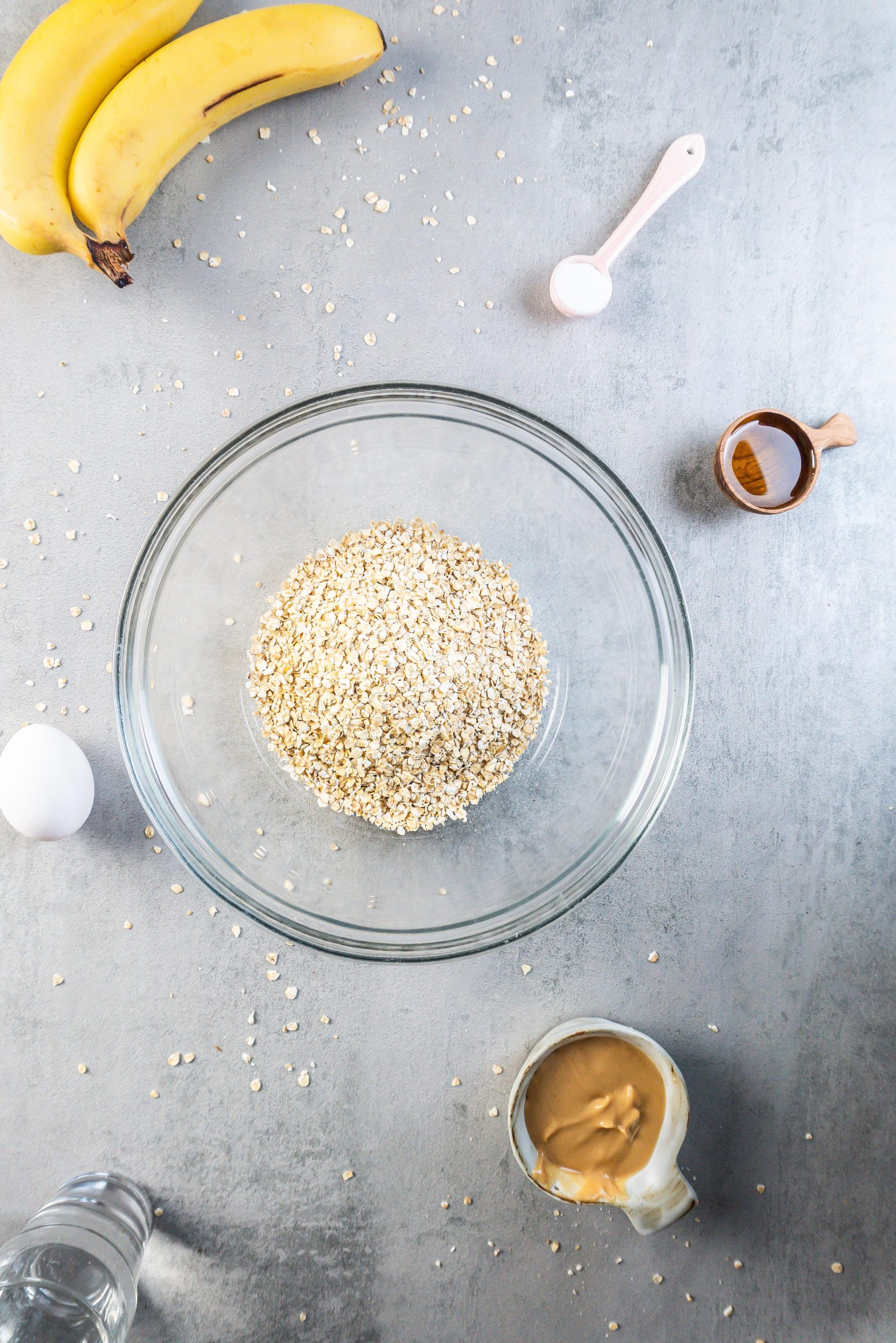 Oats in a bowl, surrounded by the other ingredients for My Dog's Birthday Breakfast Pancakes