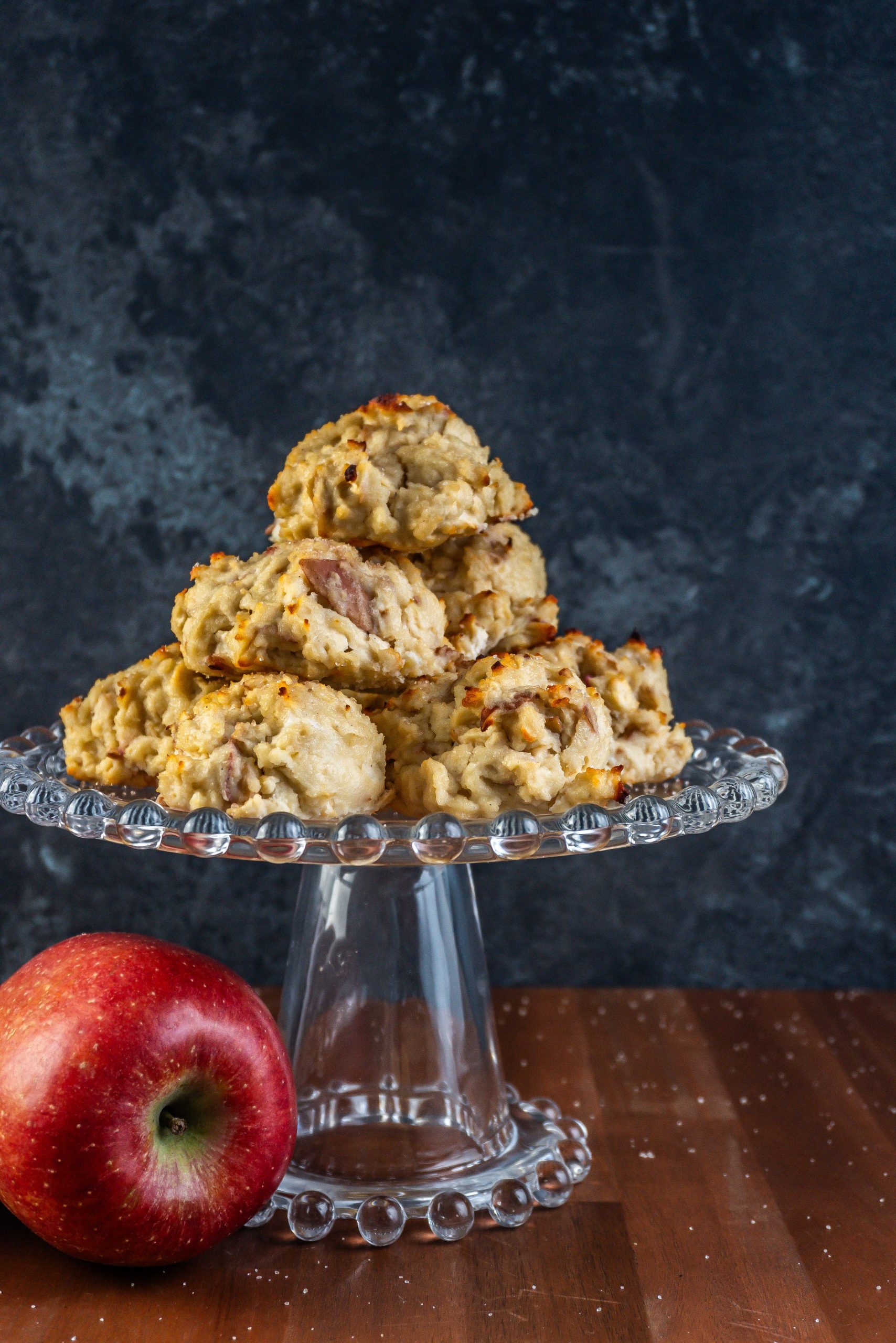 Mini Apple Quark Balls on a cake stand with an apple laying to the side; photographed up close