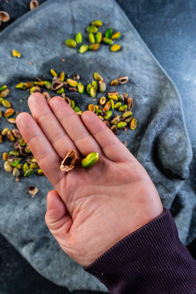 Outer skin freed from pistachio, photographed up close on a hand