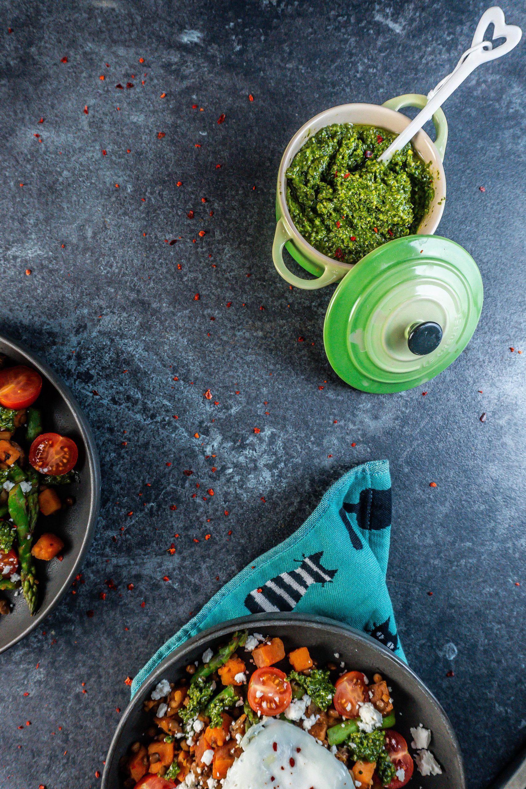 Five Minute Vegan Pepita Cilantro pesto in focus with a spoon inserted into the dish