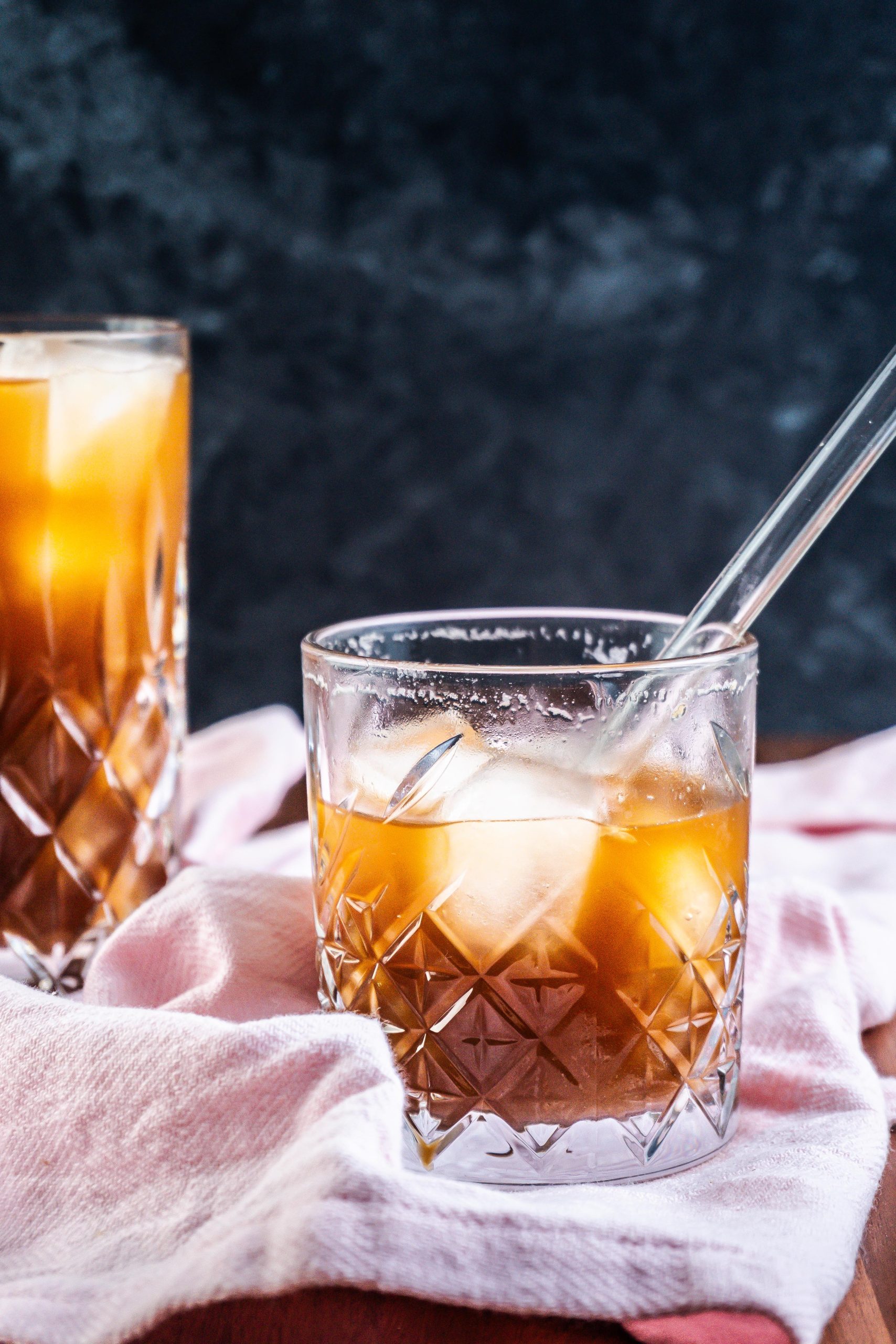 Coffee Ginger Elixir in a glass with a straw being half drunk; photographed up close