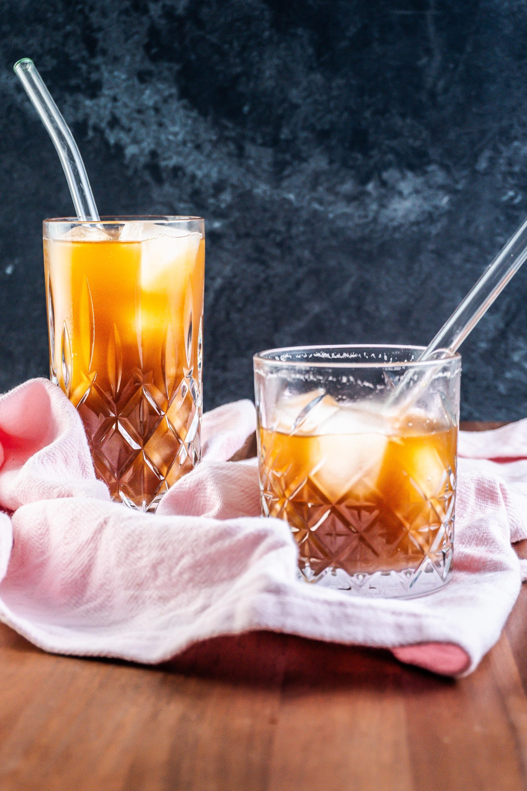 Coffee Ginger Elixir in a glass with a straw being half drunk and another glass full visible in the background