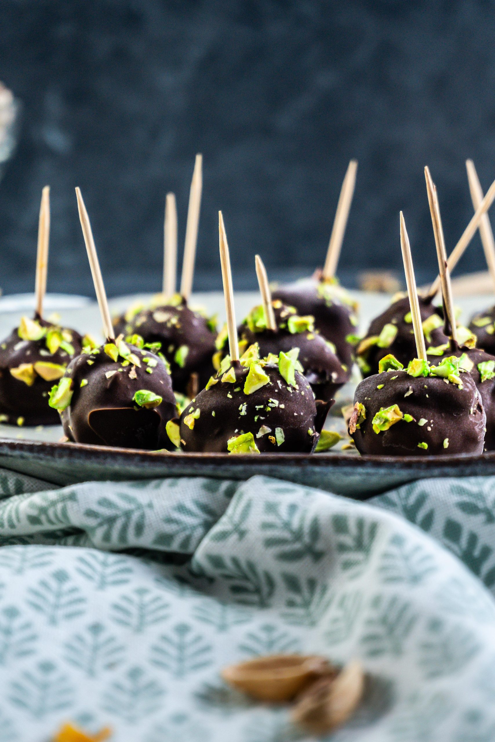 Gluten-free Dubai Style Pistachio Balls on a plate with some chopped pistachios strewn on top