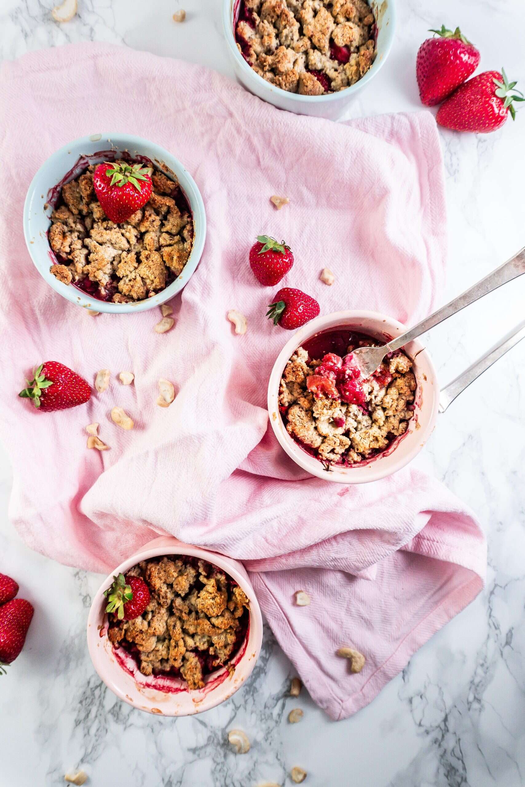 Strawberry Rhubarb Crumble in a ramekin with a fork tugging into one of the crumbles