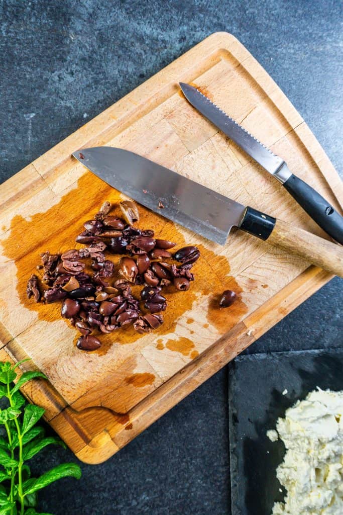 Olives being roughly chopped for this creamy whipped feta dip