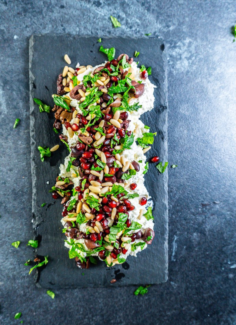 Creamy whipped feta dip on a serving plate with mint leaves strewn across the top