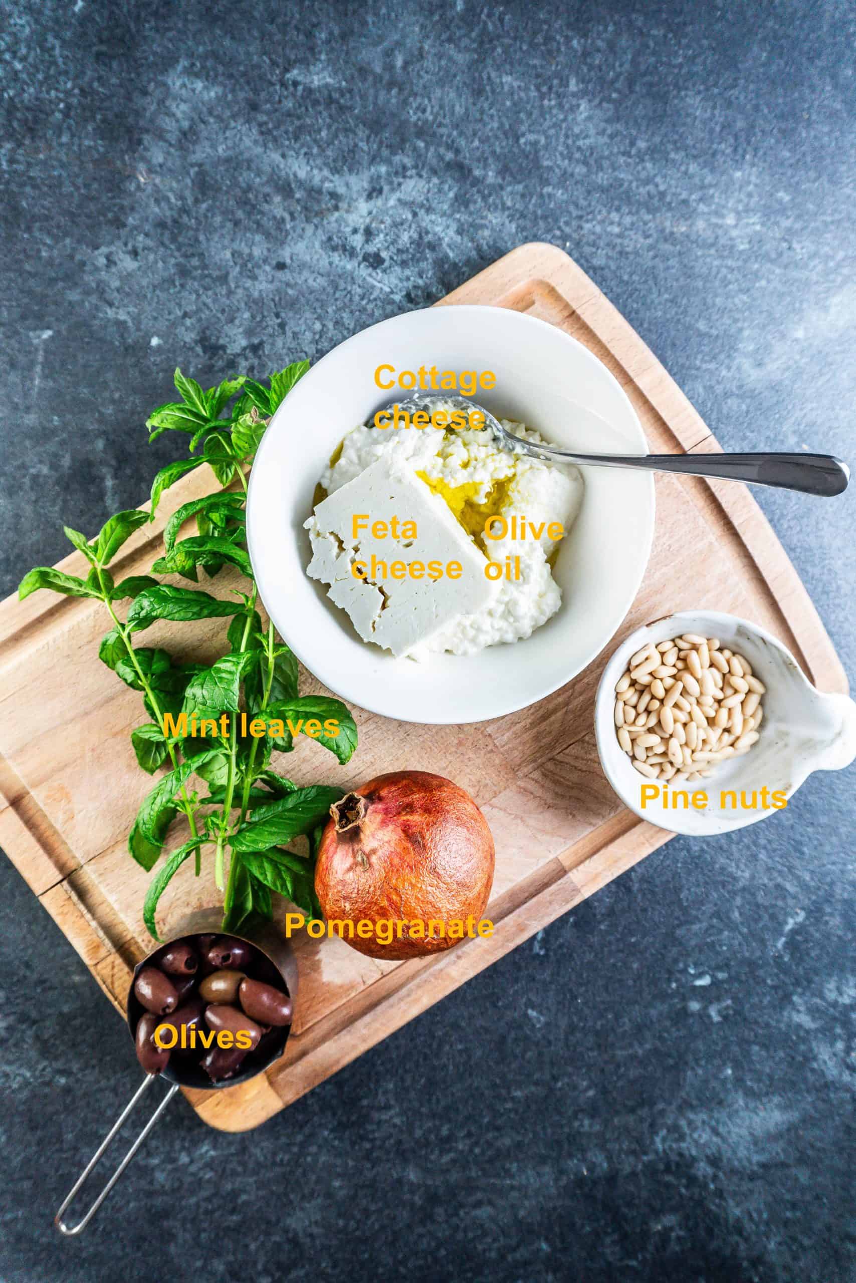Ingredients listed for this creamy whipped feta dip, spread out on a chopping board.