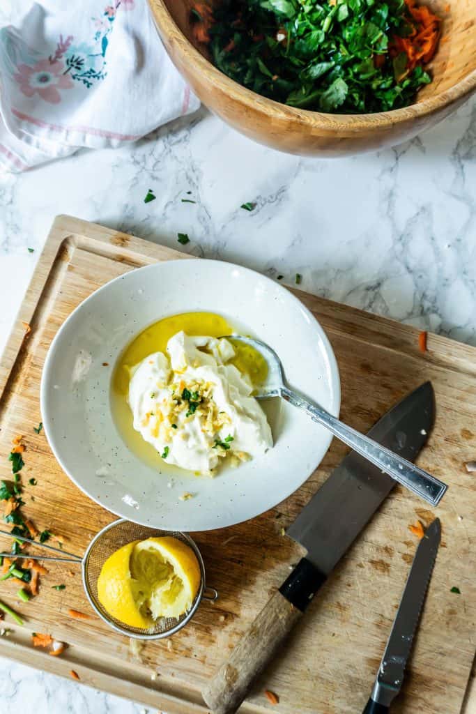 Greek yogurt, garlic, olive oil, lemon juice being combined for a zesty dressing