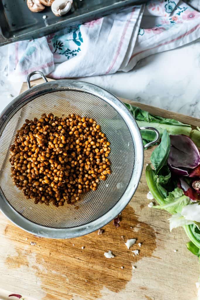 Lentils in a sieve on a chopping board