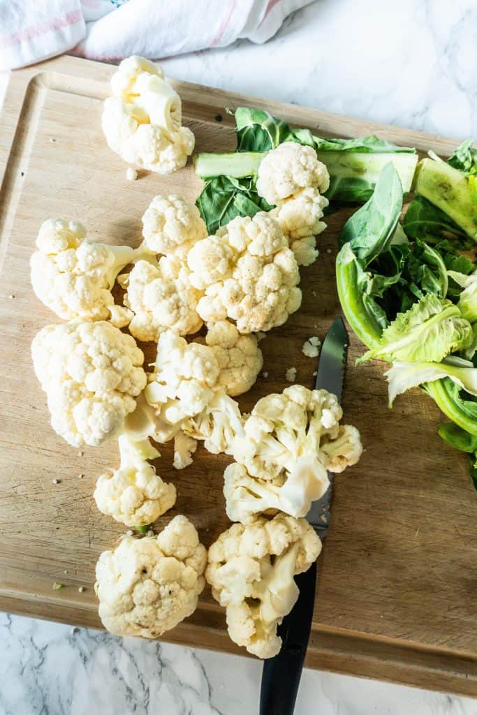 Cauliflower being chopped into individual pieces
