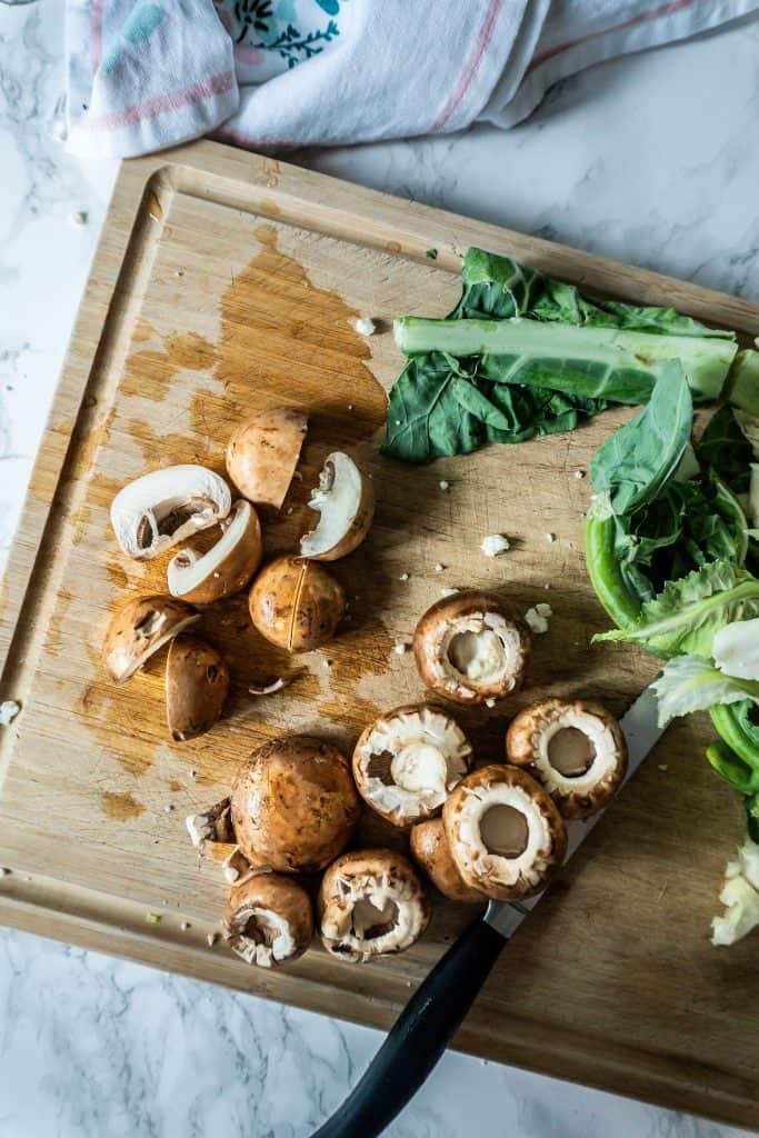 Mushrooms being chopped on a chopping board