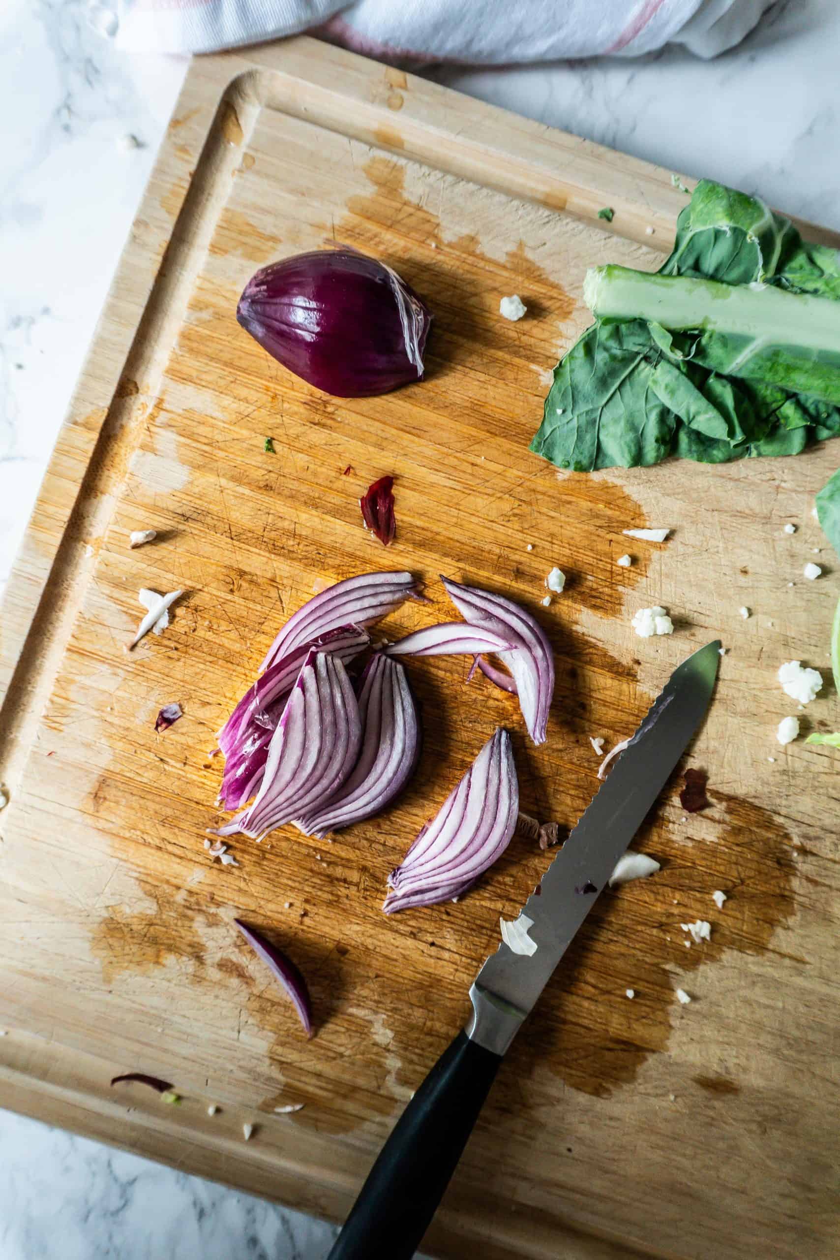 Red onions being chopped on a chopping board