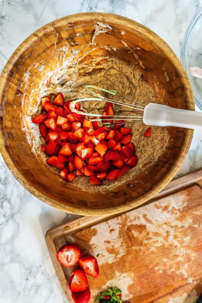 Adding strawberries to the strawberry banana muffin dough