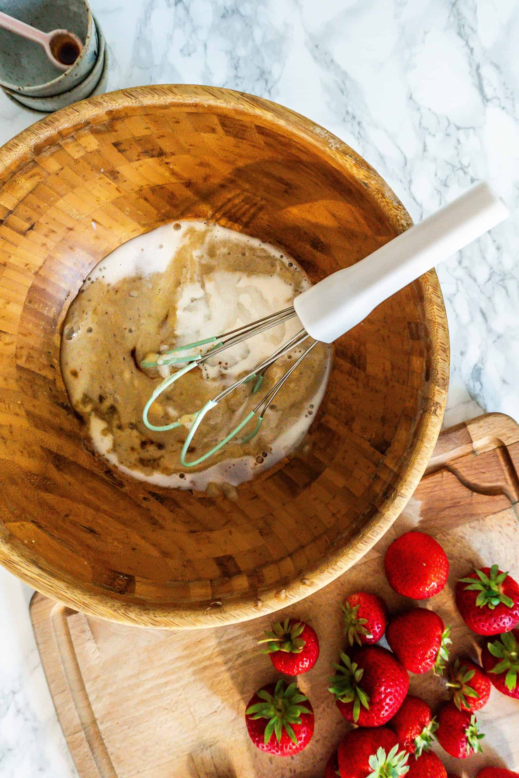 Liquid ingredients for the strawberry banana muffins mixed in a bowl