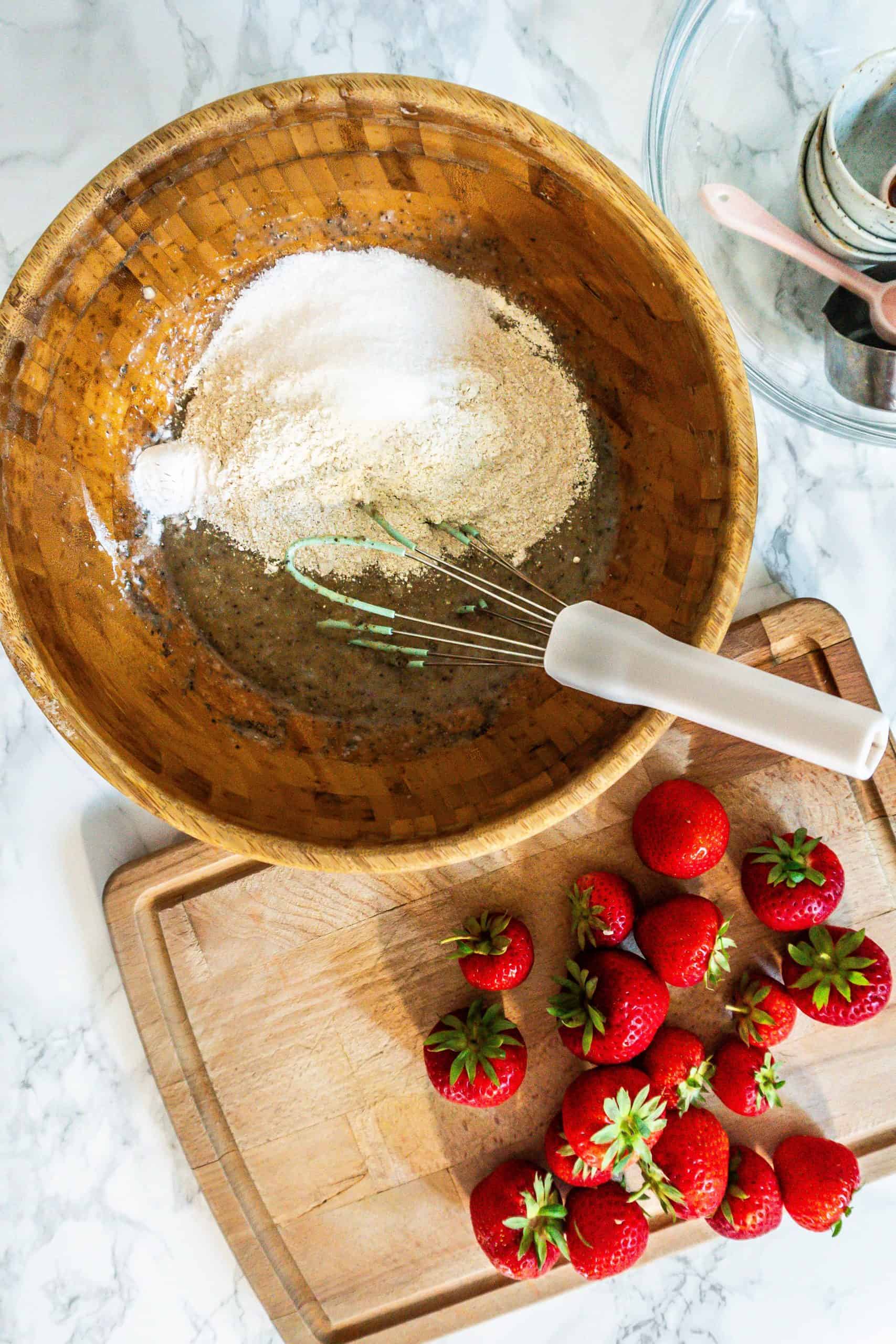Adding ground buckwheat flour, oat flour, baking powder, a pinch of salt, and xylit to the dough in order to form the base for the Strawberry Banana Muffins