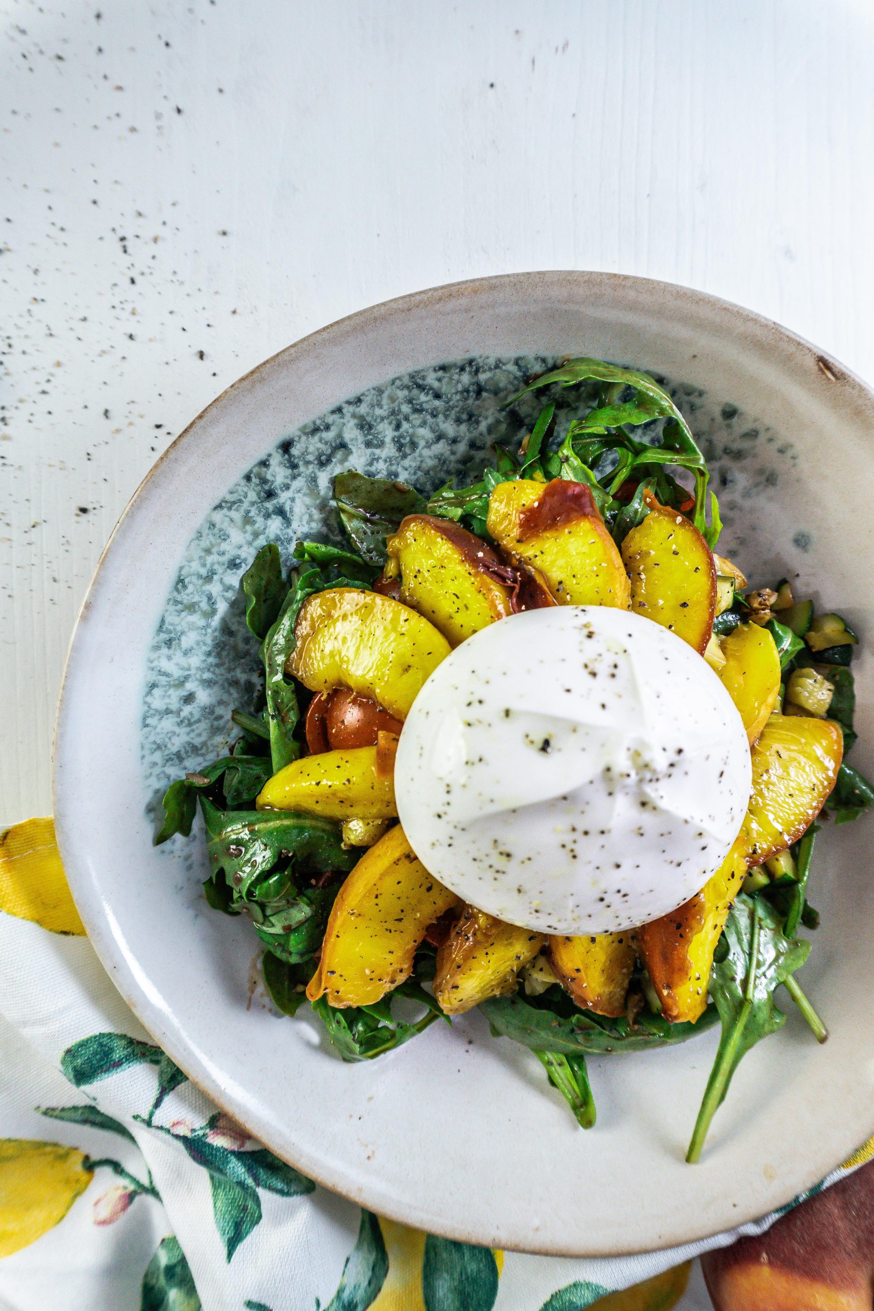 Grilled Peach Salad with Burrata on a plate photographed from above and up close