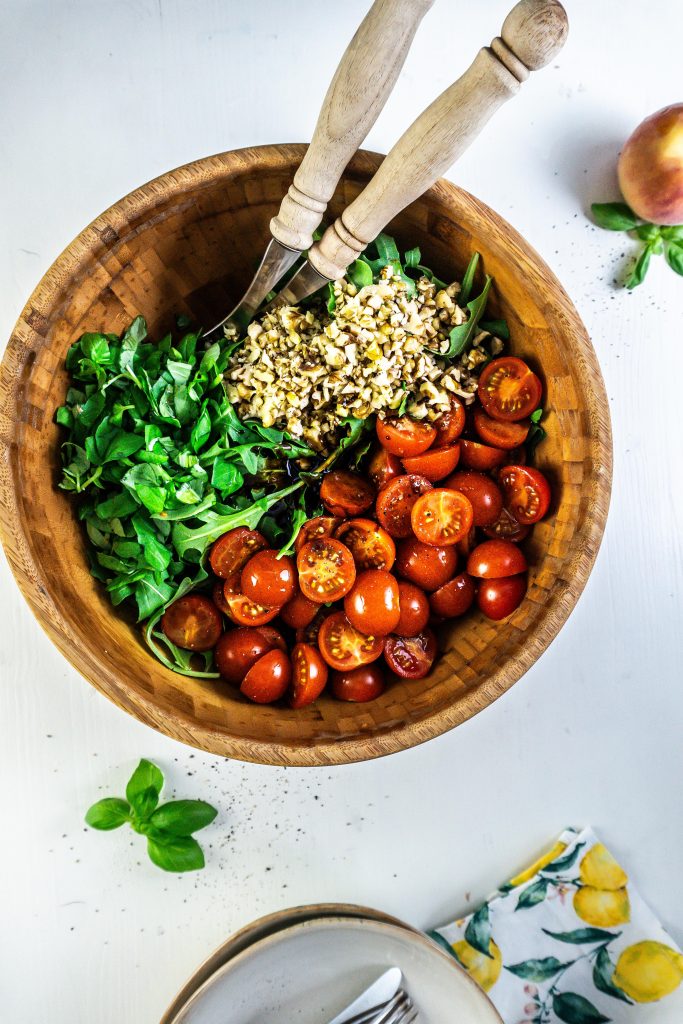 Cherry tomatoes, rocket, basil, and walnuts in a salad bowl with a balsamic glaze added